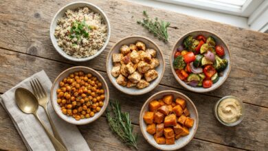 Separate bowls of chicken, chickpeas, rice, and roasted vegetables unassembled
